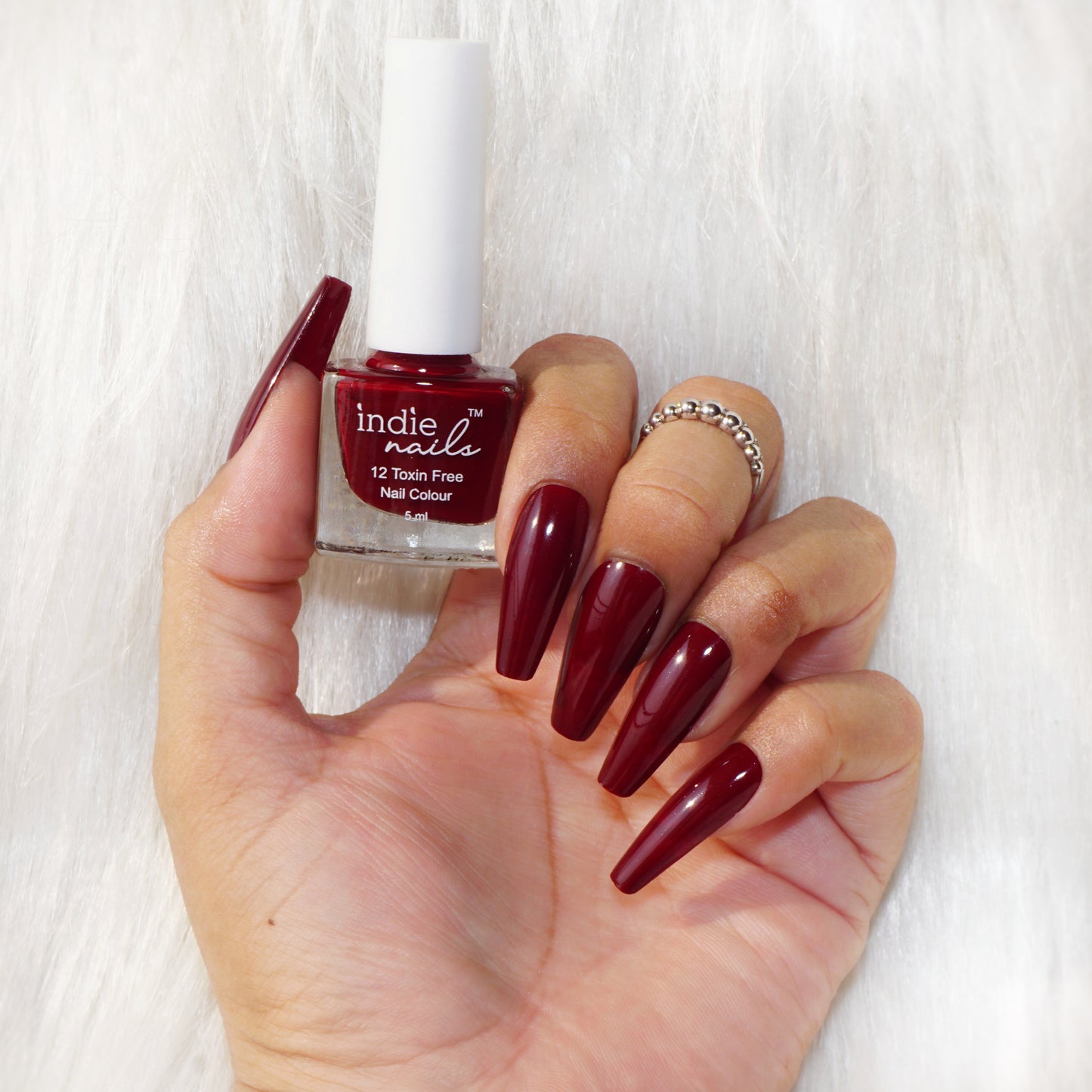 Cherry Red nail polish swatch on Indian skin tone
Indie Nails Cherry Red bottle with glassy finish, Close-up of glossy red nails painted with Indie Nails, Cherry Red