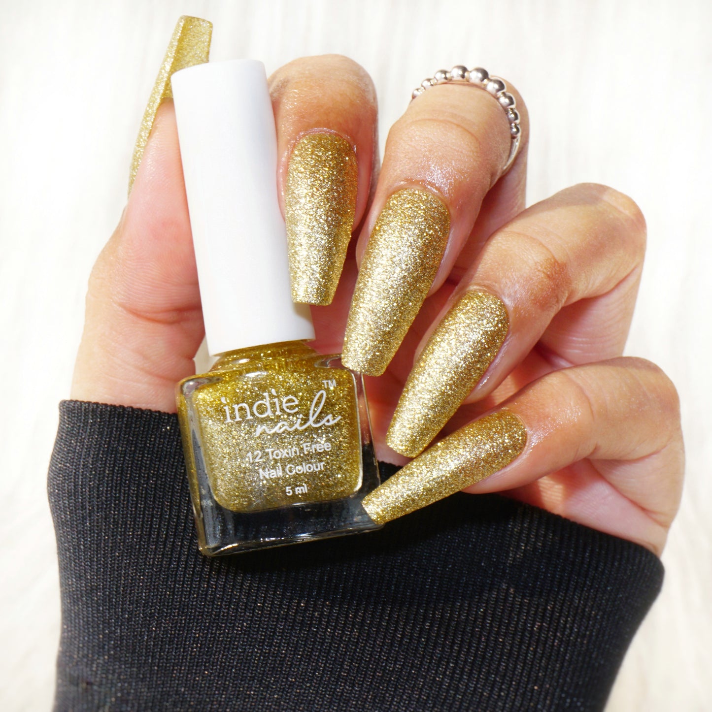 Bling Bling golden glitter nail polish bottle front view,Close-up of Bling Bling glitter on nails,Sparkly golden polish in sunlight – Indie Nails, Brush dipped in gold glitter nail polish, Festive gold glitter nail paint for weddings and parties