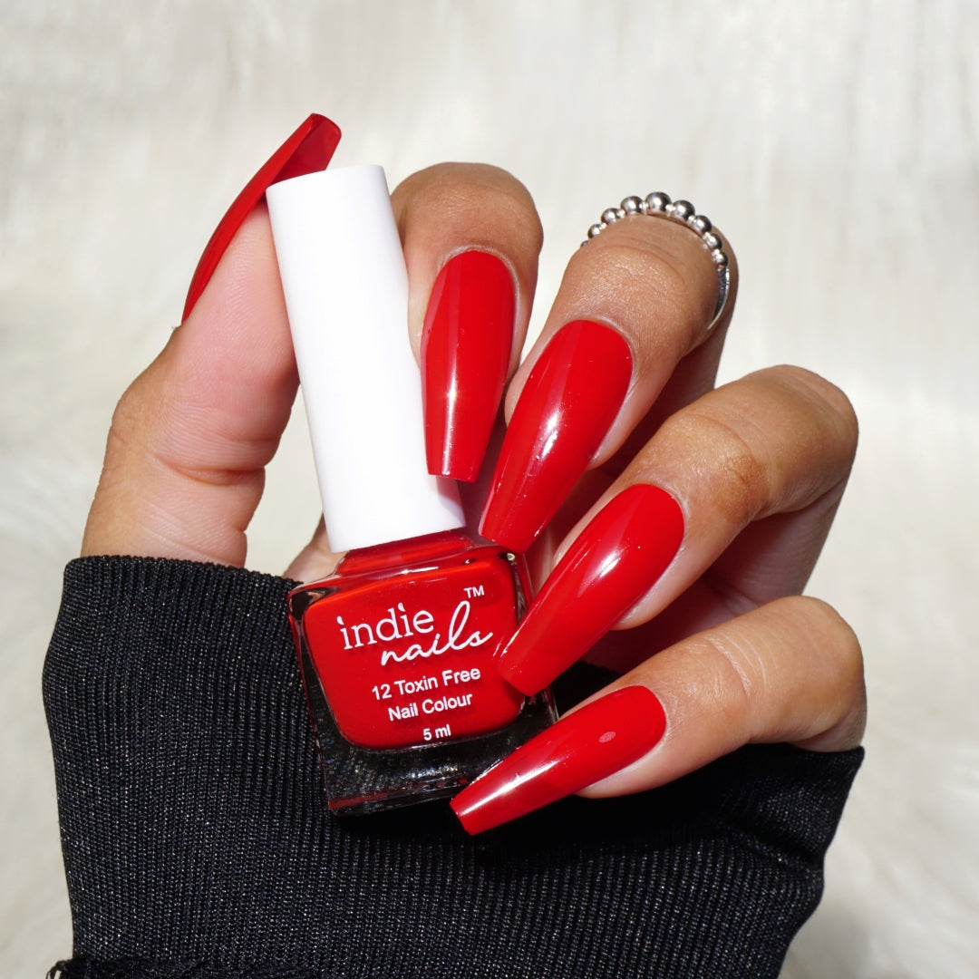 #cf020d, Bloodrush bold red nail polish bottle by Indie Nails, Deep red nail polish swatch on Indian skin tone, Glossy blood-red polish in bright lighting, Bloodrush polish applied on long nails, Indie Nails Bloodrush – intense red nail paint for bold looks