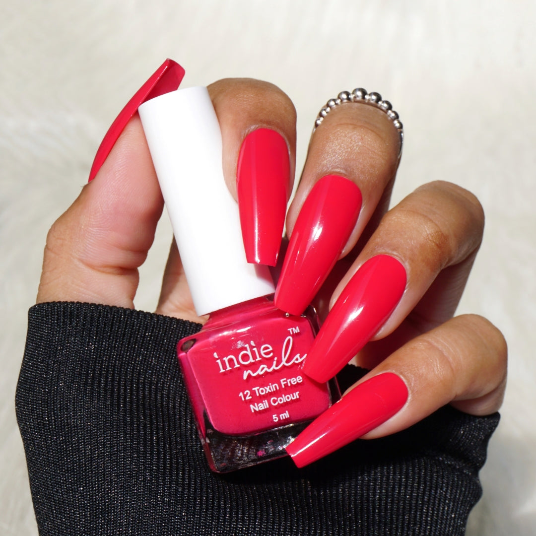 Bright rani pink nail polish on dusky Indian skin, Indie Nails Rani bottle with Indian festive decor