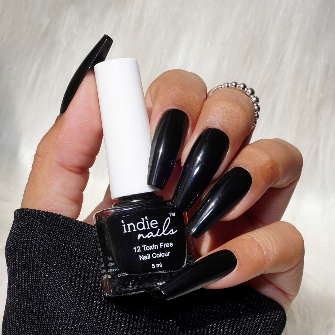 Indie Nails Midnight Affair black nail polish bottle, Jet black nail polish swatch on Indian skin, Glossy black nail polish applied on long nails, Close-up of Midnight Affair polish in sunlight, Classic black nail color by Indie Nails