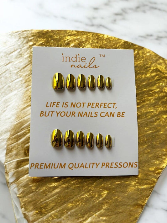 Shiny gold soft gel nails displayed in flatlay, 24 Karat Gold soft gel press-on nails kit with tools and glue