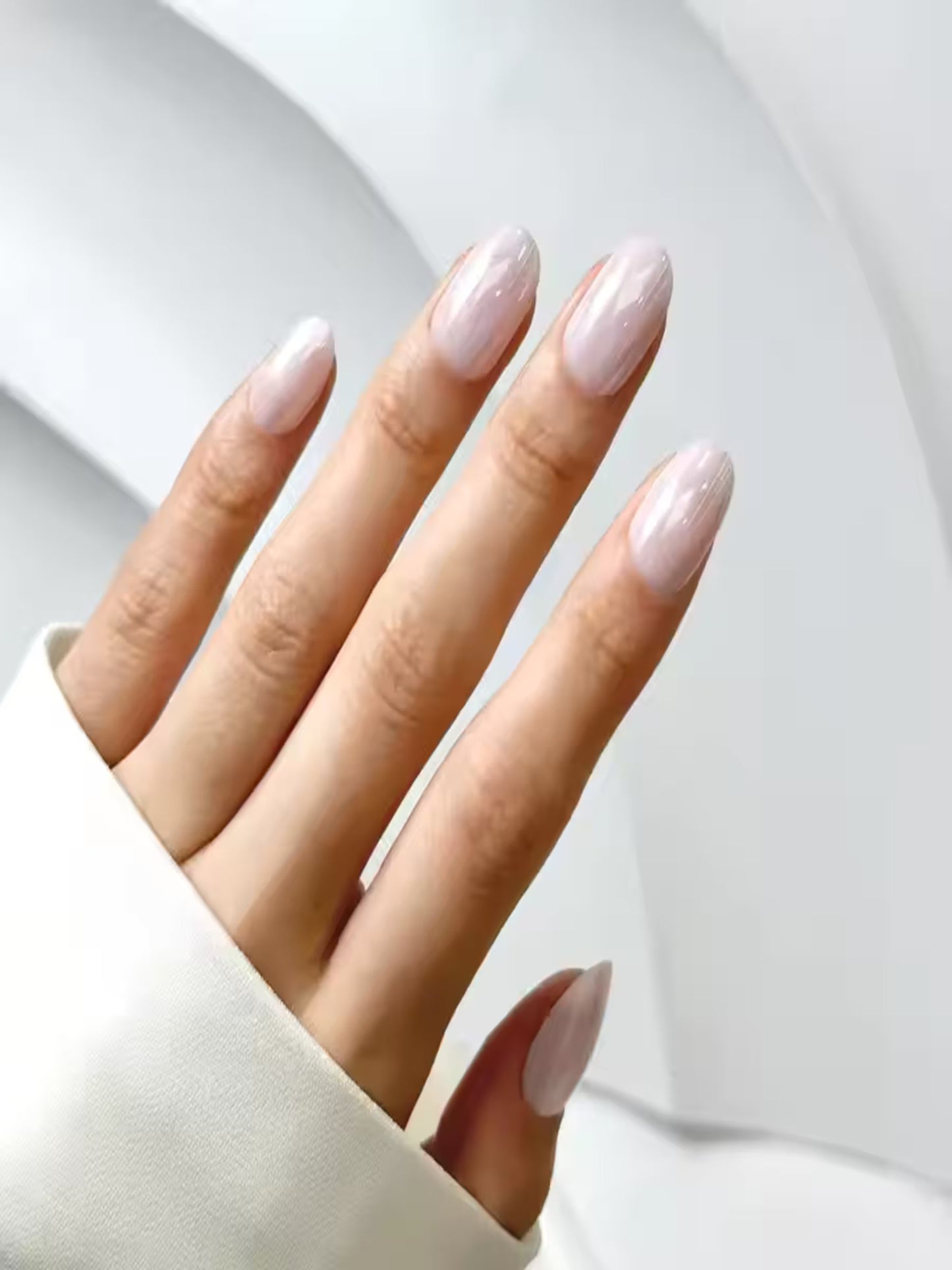 Reusable nude press-ons by Indie Nails displayed flatlay, Model wearing Beach Walk nude glossy press-on nails
